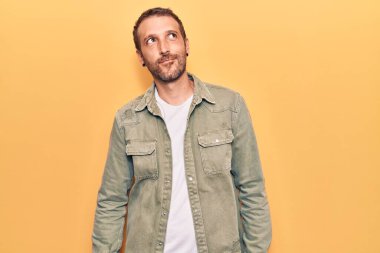 Gündelik kıyafetler giyen genç yakışıklı adam gülümseyerek yan tarafa bakıyor ve düşünüyor.. 