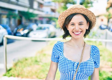 Genç ve güzel bir kız gülümsüyor. Mutlu bir şekilde yürüyor.