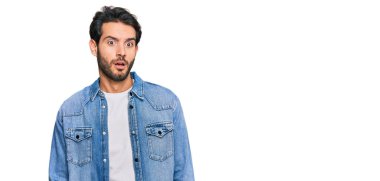 Şok olmuş gibi giyinen genç İspanyol adam şüpheci ve alaycı görünüyor, ağzı açık kalınca şaşırıyor. 