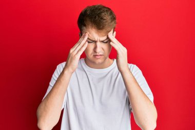 Kafkasyalı genç bir adam, günlük beyaz tişört giyiyordu. Elleri başının üstünde, stres yüzünden baş ağrısı vardı. migren ağrısı. 