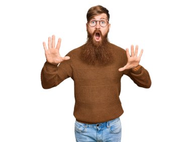 Genç İrlandalı kızıl elbiseli ve gözlüklü adam avuçlarıyla jestleri durduruyor, sinirli ve hayal kırıklığına uğramış bir ifade takınıyor. 