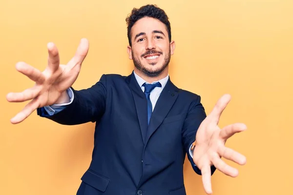 Joven Hispano Vestido Traje Mirando Cámara Sonriendo Con Los Brazos —  Fotos de Stock