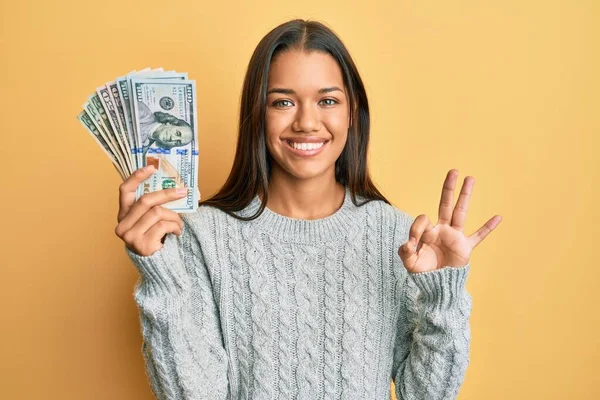 Krásná Hispánka Drží Dolary Dělá Znamení Prsty Usmívá Přátelsky Gestikulující — Stock fotografie