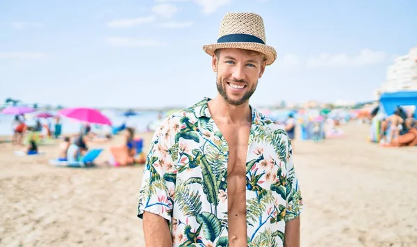 在阳光灿烂的日子 一个戴着夏帽的英俊的白人男子站在海滩上 — 图库照片