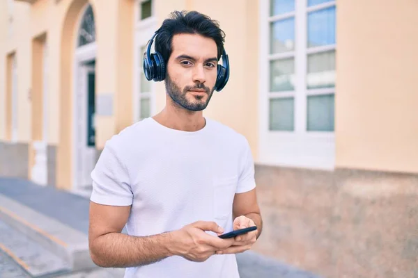 Jovem Hispânico Com Expressão Séria Usando Smartphone Fones Ouvido Cidade — Fotografia de Stock