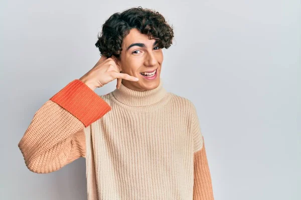 Latynoski Młodzieniec Zimowym Swetrze Uśmiechnięty Telefonem Ręką Palcami Jakby Rozmawiał — Zdjęcie stockowe
