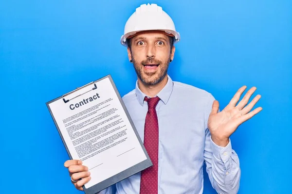 Jovem Homem Bonito Vestindo Arquiteto Hardhat Segurando Documento Contrato Celebrando — Fotografia de Stock