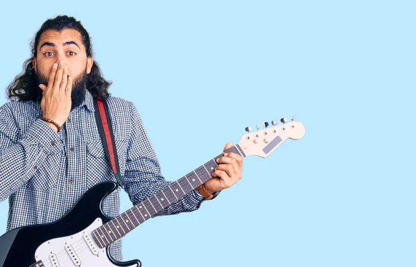 若いアラブ人の男は手で口をカバーする電気ギターを演奏し ショックを受け 間違いを恐れている 驚きの表情 — ストック写真