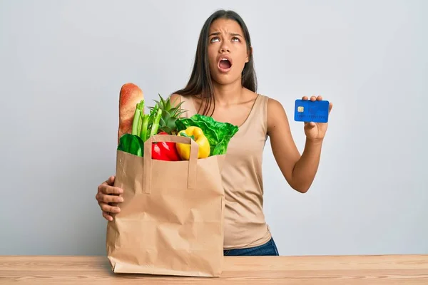 Beautiful Hispanic Woman Holding Groceries Credit Card Angry Mad Screaming — Stock Photo, Image