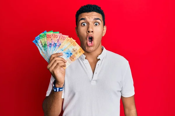 Young Arab Man Holding Swiss Franc Banknotes Scared Amazed Open —  Fotos de Stock