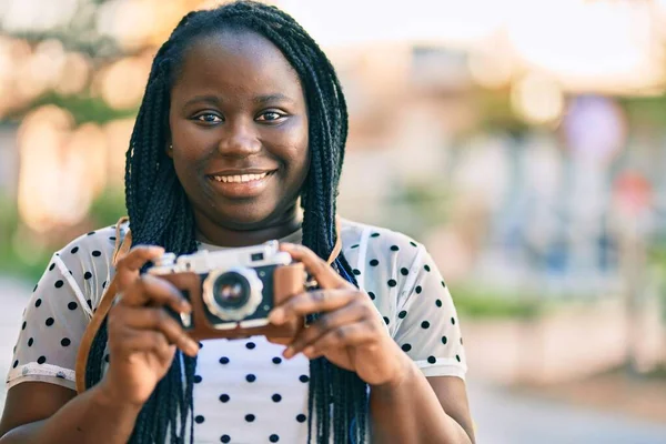 年轻的非洲裔美国女游客在城里用老式相机开心地微笑着 — 图库照片
