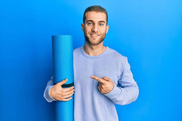 Giovane Uomo Caucasico Che Tiene Tappetino Yoga Sorridente Felice Indicando — Foto Stock