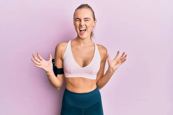 Beautiful Blonde Woman Wearing Sportswear Arm Band Crazy Mad Shouting — Stock Photo, Image