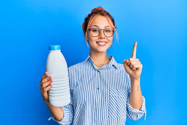 Молода Руда Жінка Тримає Літрову Пляшку Молока Посміхаючись Ідеєю Або — стокове фото