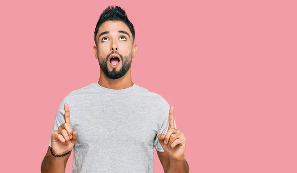 Joven Con Barba Vestida Con Camiseta Gris Casual Asombrado Sorprendido —  Fotos de Stock