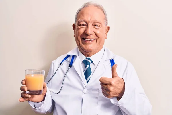 Starszy Siwowłosy Lekarz Noszący Stetoskop Pijący Szklankę Zdrowego Soku Pomarańczowego — Zdjęcie stockowe