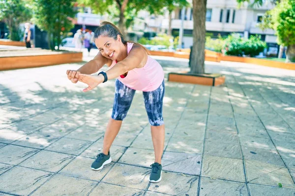 公園で幸せな訓練を笑っている中年のスポーツ女性 — ストック写真