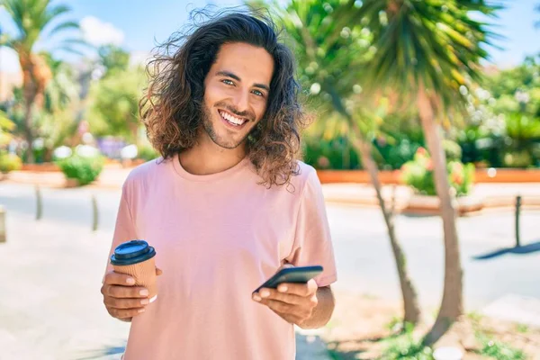 Ung Latinamerikansk Man Ler Glad Med Smartphone Och Dricka Bort — Stockfoto