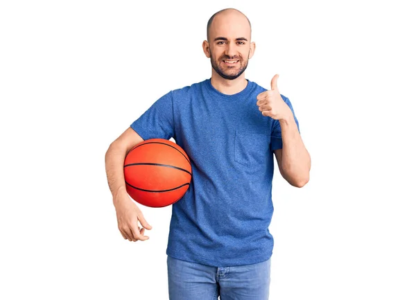 年轻英俊的男子拿着篮球 面带微笑 面带微笑 大拇指向上做得很出色 并签了字 — 图库照片
