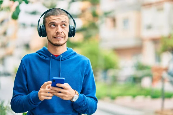 Jonge Spaanse Man Glimlacht Gelukkig Met Behulp Van Smartphone Koptelefoon — Stockfoto