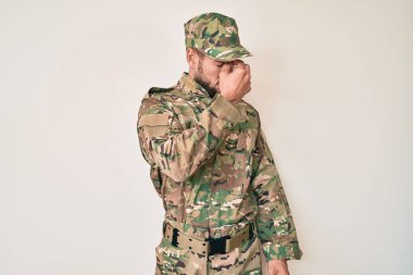 Kafkasyalı genç adam kamuflaj üniforması giyiyor. Burnu ve gözleri ovuşturmaktan yorulmuş. Yorgunluk ve baş ağrısı çekiyor. Stres ve hüsran kavramı. 