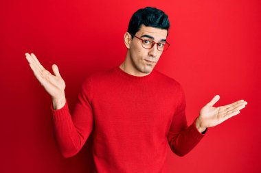 Sıradan kıyafetler ve gözlük takan yakışıklı İspanyol adam habersiz ve kolları açık, hiçbir fikrim yok ve şüpheli bir yüz.. 