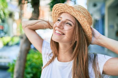 Genç sarışın kadın tatilde gülümsüyor. Mutlu bir şekilde caddede yürüyor.