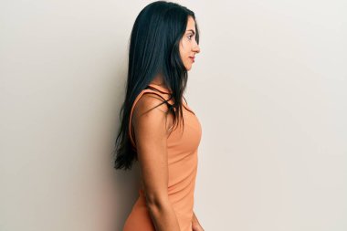 Yazlık elbiseler giyen güzel İspanyol kadın, rahat bir görünüm ve kendine güvenen bir gülümsemeyle poz veriyor.. 