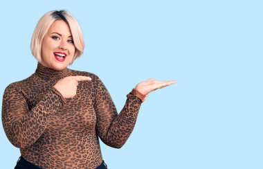 Sıradan bir leopar tişörtü giyen genç sarışın ve cüsseli bir kadın kameraya hayret ediyor ve gülümsüyor.. 