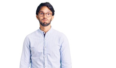 İş gömleği giyen, gözlüklü, komik yüzlü yakışıklı bir İspanyol. Havayla şişmiş ağız, çılgın bir ifade.. 