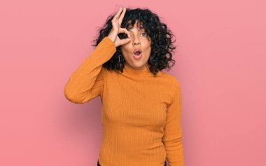 Gündelik kıyafetler giyen genç İspanyol kadın şaşırmış yüz ifadesiyle şok olmuş, parmaklarından bakan gözler. İnançsız ifade. 