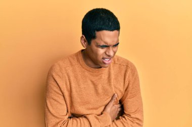 Genç, yakışıklı İspanyol bir adam, elleri karnında, sıradan bir kazak giyiyor çünkü mide bulantısı, acı verici bir hastalık kendini iyi hissetmiyor. Ağrı kavramı. 