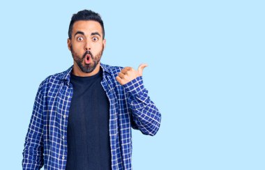 Gündelik giysiler giyen genç İspanyol adam elleri yana doğru işaret ederek şaşırdı, ağzı açık hayret içinde kaldı.. 