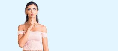 Genç ve güzel bir kadın günlük giysiler giyip şüpheye odaklanmıştı. Parmakları çenesinde ve yukarı bakıyordu. 