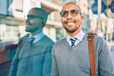 Genç Afrikalı Amerikalı iş adamı gülümsüyor. Şehrin duvarına yaslanmaktan mutlu..