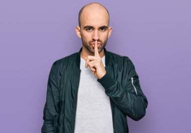 Gündelik kıyafetler giyen genç İspanyol adam parmakları dudaklarında sessiz olmak istiyor. sessizlik ve gizli konsept. 