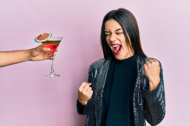 Seksi parti ceketi giyen ve İspanyol kollu genç bir kız kolları kapalı, kolları havada ve gözleri kapalı bir şekilde zafer kutlamaları sunuyor. 