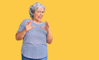 Gri saçlı, sıradan çizgili giysiler giyen yaşlı bir kadın tiksinti dolu ve tiksindirici bir ifade takınıyordu. Çünkü tiksinti tepki gösteriyordu. Eller havada. 