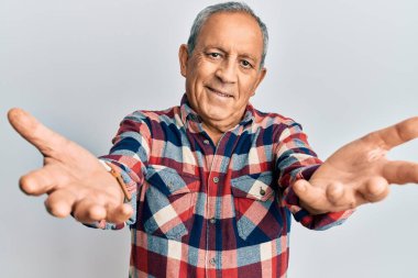 Üst düzey İspanyol adam sıradan kıyafetler giyip kameraya bakıyor. Sarılmak için kollarını açmış gülümsüyor. Mutluluğu kucaklayan neşeli bir ifade.. 