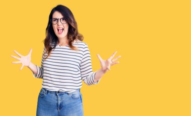 Güzel, genç, esmer bir kadın. Günlük kıyafetler ve gözlükler takıyor. Deli gibi bağırıyor, agresif bir ifade ve kollarla bağırıyor. hüsran kavramı. 