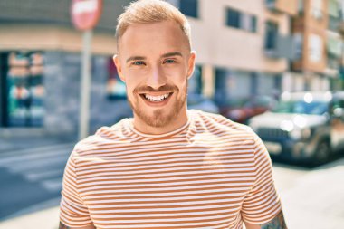 Genç İrlandalı adam gülümsüyor. Şehrin caddesinde mutlu bir şekilde yürüyor..