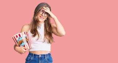 Güzel beyaz kadın elinde patlamış mısır tutarken gergin ve hayal kırıklığına uğramış, şaşırmış ve kızgın bir yüz. 