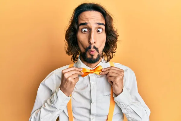 Jovem Hispânico Vestindo Hipster Elegante Olhar Segurando Bowtie Fazendo Cara — Fotografia de Stock