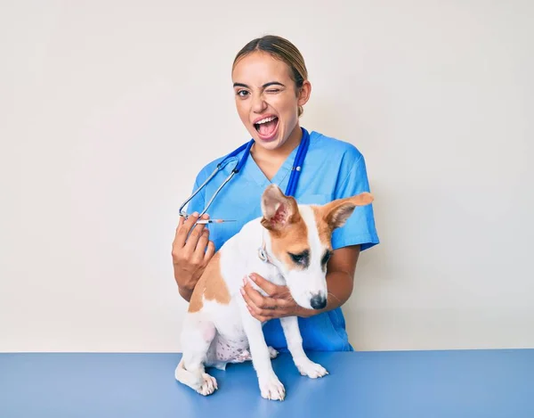 Giovane Bella Donna Veterinaria Bionda Mettendo Vaccino Cucciolo Cane Ammiccante — Foto Stock