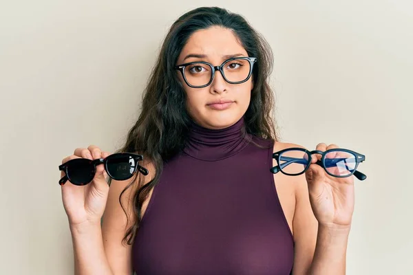 Hermosa Mujer Oriente Medio Sosteniendo Diferentes Gafas Escéptico Nervioso Frunciendo —  Fotos de Stock