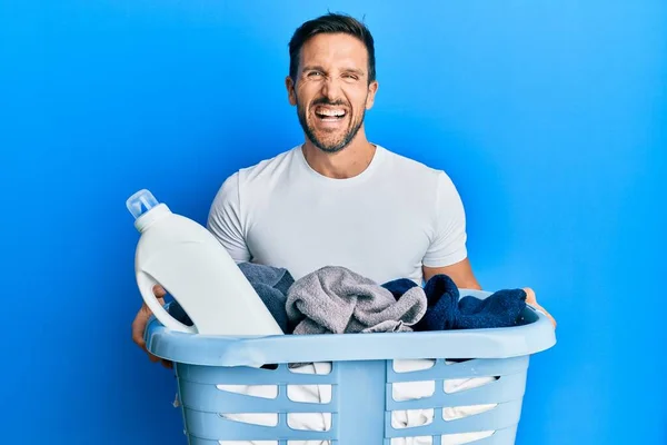 Jovem Homem Bonito Segurando Cesta Roupa Garrafa Detergente Sorrindo Rindo — Fotografia de Stock