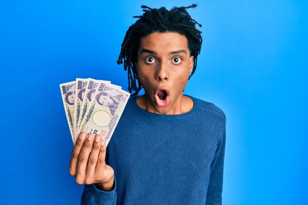 Νεαρός Αφροαμερικάνος Που Κρατάει Χαρτονομίσματα 5000 Γιεν Φοβισμένος Και Έκπληκτος — Φωτογραφία Αρχείου