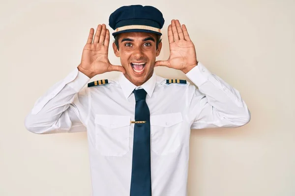 Mladý Hispánec Uniformě Pilota Letadla Vesele Usmívá Dívá Boo Rukama — Stock fotografie