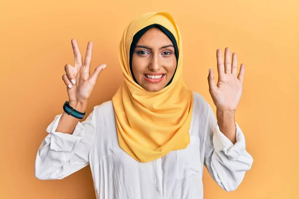 若いですブルネットArab女性身に着けています伝統的なイスラムヒジャーブスカーフショーと指番号8で指摘しながら 自信と幸せ — ストック写真