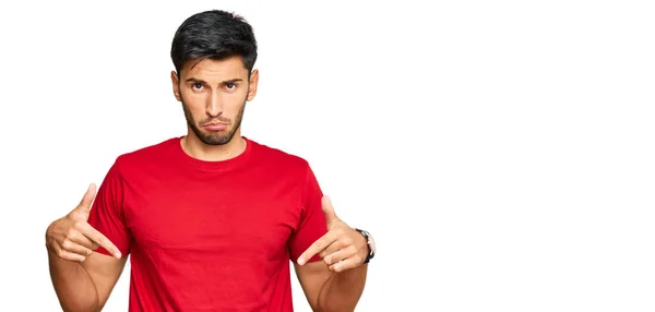 Joven Hombre Guapo Con Camiseta Roja Casual Apuntando Hacia Abajo —  Fotos de Stock